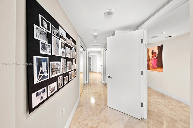 hall with marble finish floor, visible vents, and baseboards