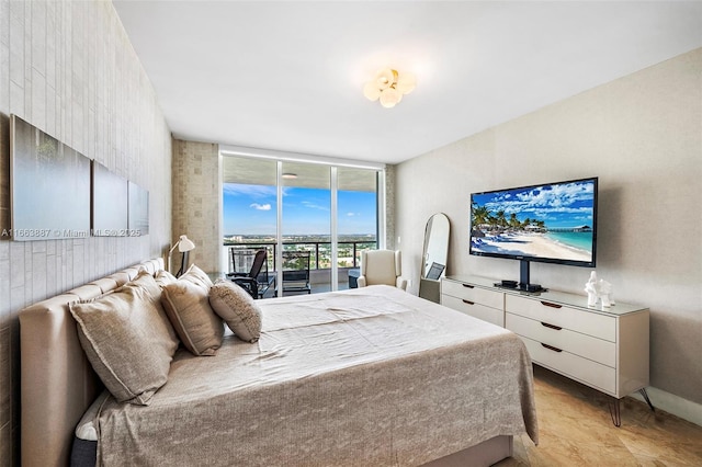 bedroom with expansive windows, baseboards, and access to exterior