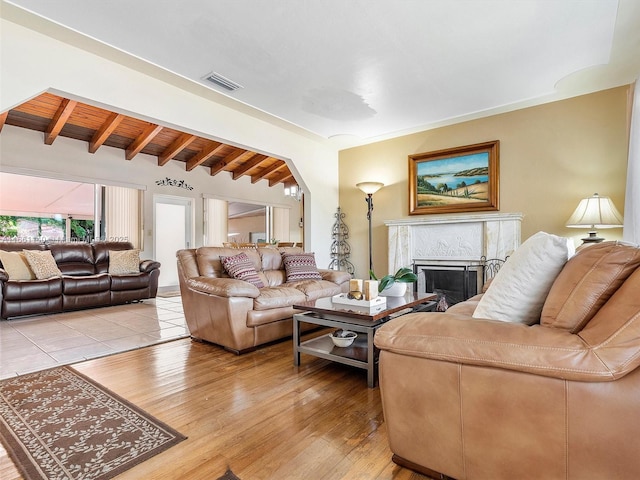 living room featuring wood ceiling, wood-type flooring, beam ceiling, and a premium fireplace