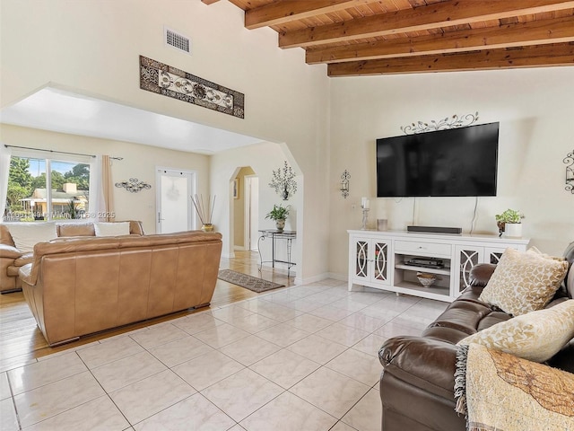 tiled living room featuring beam ceiling, wooden ceiling, and a high ceiling