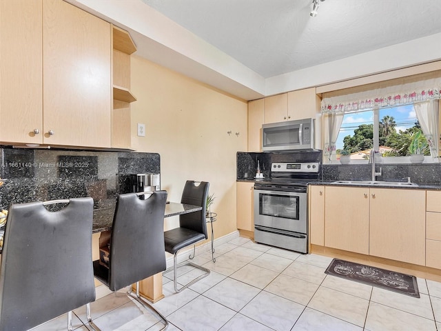 2380 SW 7th St, Miami, FL 33135 - kitchen with stainless steel appliances, open shelves, backsplash, light brown cabinets, and dark stone counters