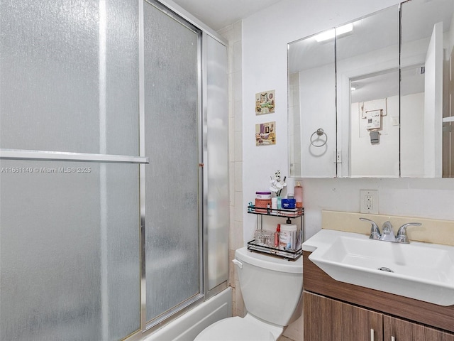 full bathroom with vanity, enclosed tub / shower combo, and toilet