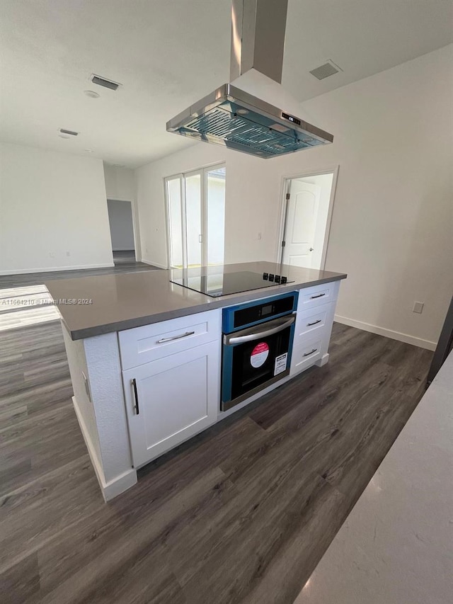 kitchen featuring island range hood, white cabinetry, stainless steel oven, black electric stovetop, and dark hardwood / wood-style flooring