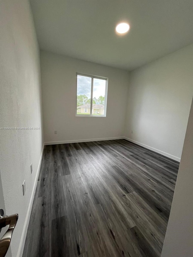 spare room featuring dark wood-type flooring