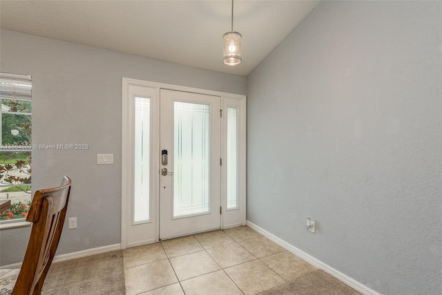 tiled foyer with lofted ceiling