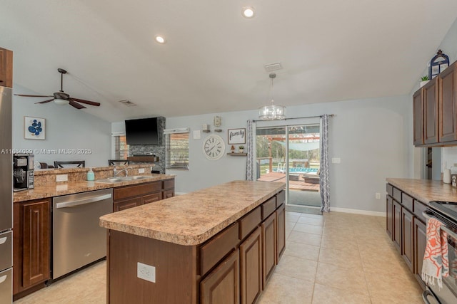 kitchen featuring sink, decorative light fixtures, a center island, vaulted ceiling, and stainless steel appliances