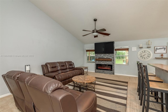 living room with vaulted ceiling, ceiling fan, and a fireplace