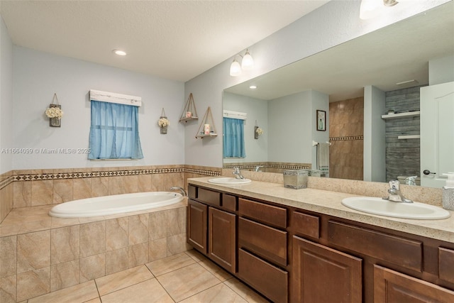 bathroom with tile patterned flooring, vanity, and plus walk in shower