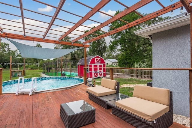 view of swimming pool with a storage unit, a pergola, a deck, and a lawn