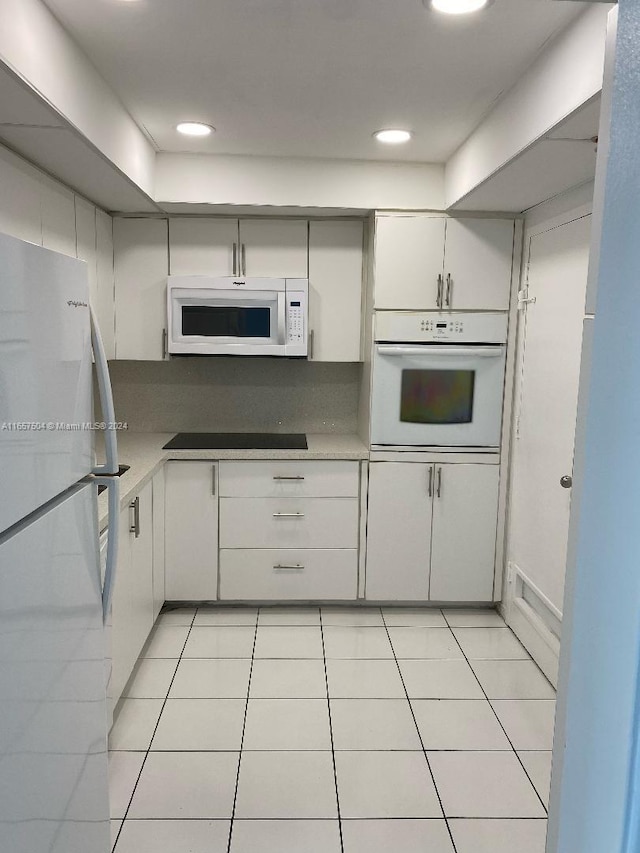 kitchen featuring white cabinets, white appliances, and light tile patterned flooring