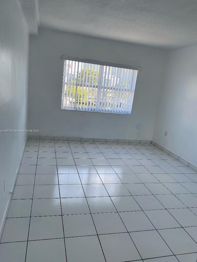 unfurnished room featuring a textured ceiling and tile patterned flooring