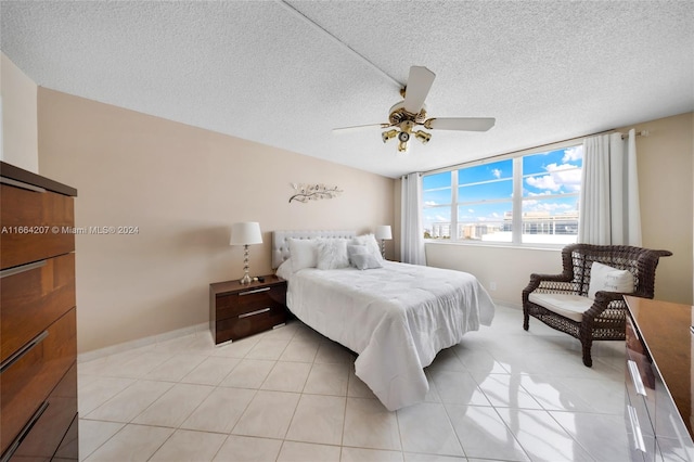 tiled bedroom featuring ceiling fan and a textured ceiling