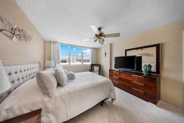 bedroom featuring ceiling fan, a textured ceiling, and light tile patterned flooring