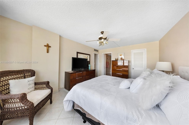 tiled bedroom featuring ceiling fan and a textured ceiling