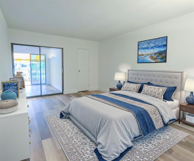 bedroom with access to exterior and hardwood / wood-style flooring