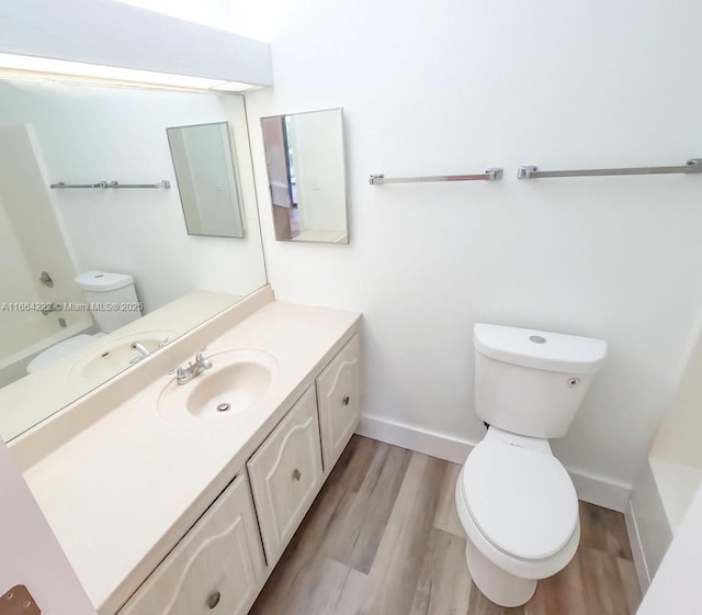 bathroom featuring toilet, vanity, and hardwood / wood-style floors