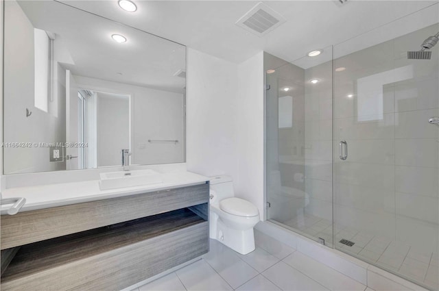 bathroom featuring tile patterned flooring, a shower with door, vanity, and toilet