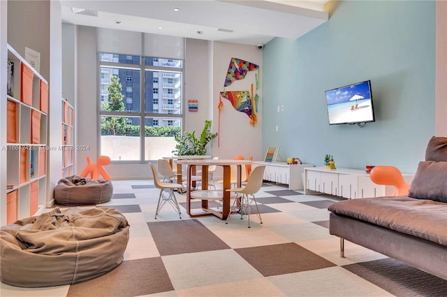 living room with carpet and a towering ceiling