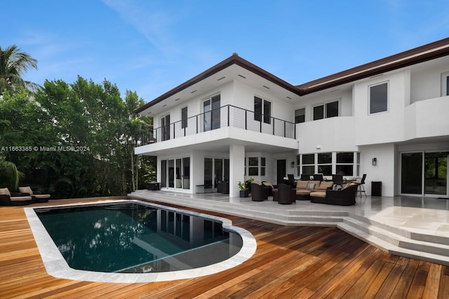 325 Campana Ave, Coral Gables, FL 33156 - rear view of house with a balcony, an outdoor living space, stucco siding, and an outdoor pool