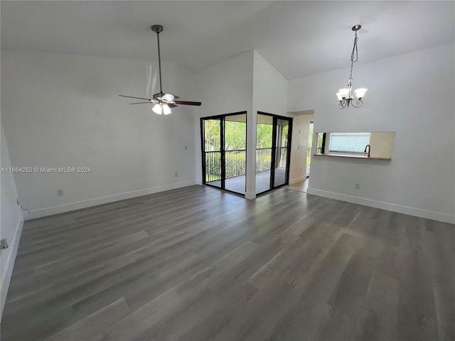 unfurnished room with ceiling fan with notable chandelier, dark hardwood / wood-style floors, high vaulted ceiling, and a healthy amount of sunlight