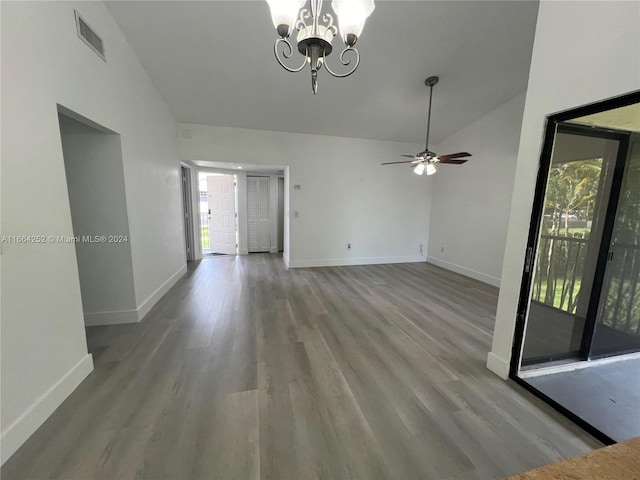 interior space with a healthy amount of sunlight, ceiling fan with notable chandelier, vaulted ceiling, and light hardwood / wood-style flooring