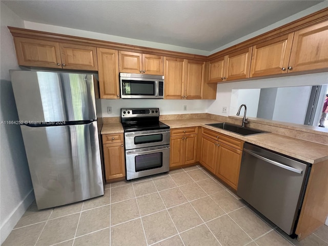 kitchen with light tile patterned floors, stainless steel appliances, and sink