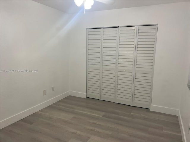 unfurnished bedroom featuring a closet and hardwood / wood-style flooring