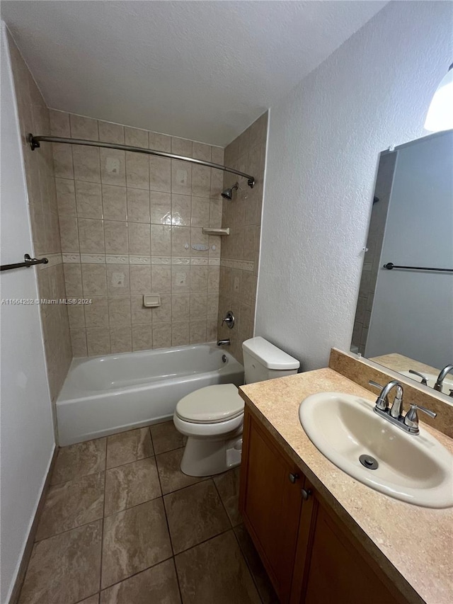 full bathroom featuring tile patterned flooring, a textured ceiling, tiled shower / bath combo, vanity, and toilet