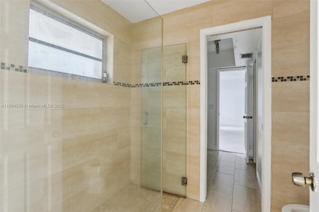 kitchen with decorative backsplash, light tile patterned flooring, kitchen peninsula, and dishwasher