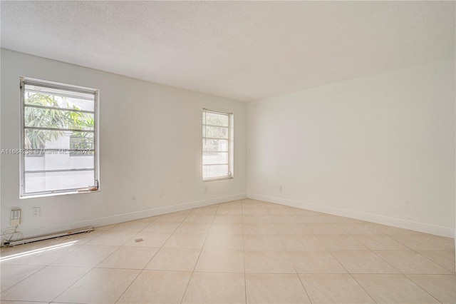 tiled spare room with a textured ceiling