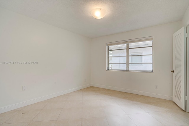 tiled spare room with a textured ceiling