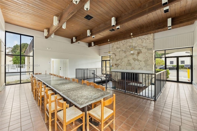 kitchen with a high ceiling, beamed ceiling, wood ceiling, and tile patterned floors