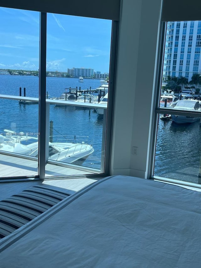 unfurnished bedroom featuring multiple windows and a water view