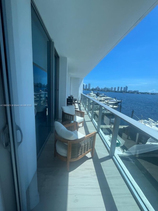 balcony with a water view and a view of city