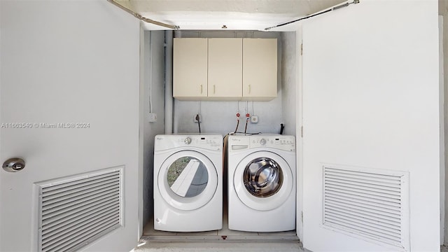 laundry room featuring independent washer and dryer and cabinets