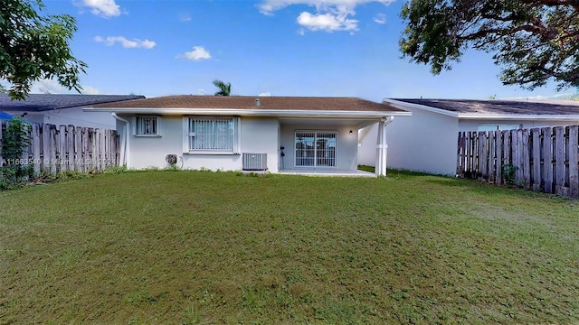 rear view of property featuring a yard, a patio area, and central AC