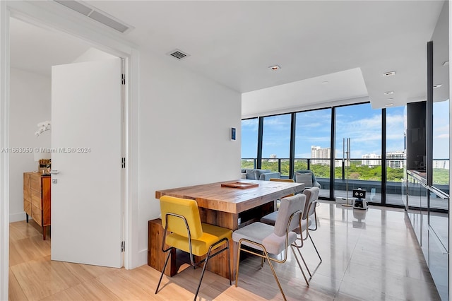 dining area featuring light hardwood / wood-style floors and a wall of windows