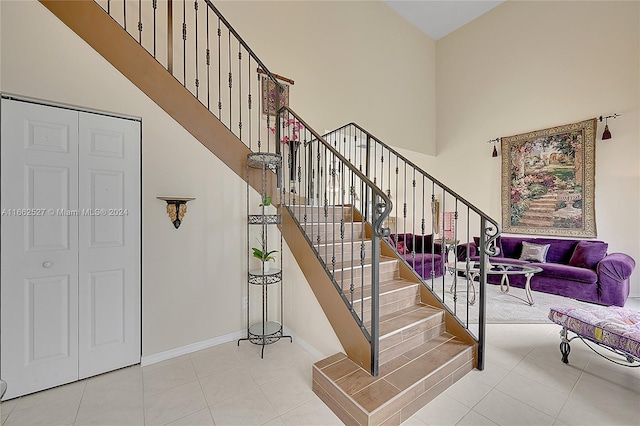 stairs featuring a high ceiling and tile patterned floors