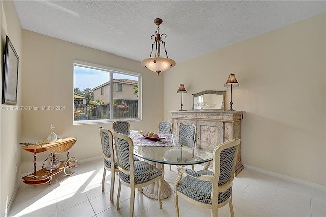 dining space featuring a textured ceiling and light tile patterned flooring