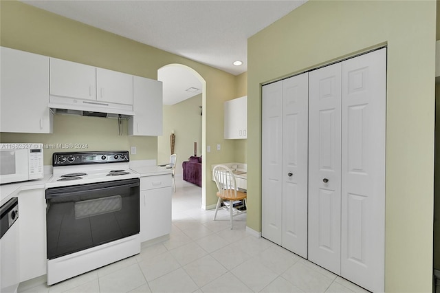 kitchen with white appliances, light tile patterned floors, and white cabinets