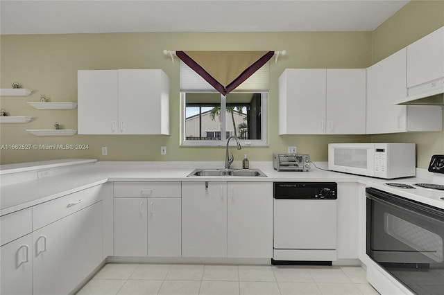 kitchen featuring white appliances, white cabinetry, light tile patterned flooring, and sink