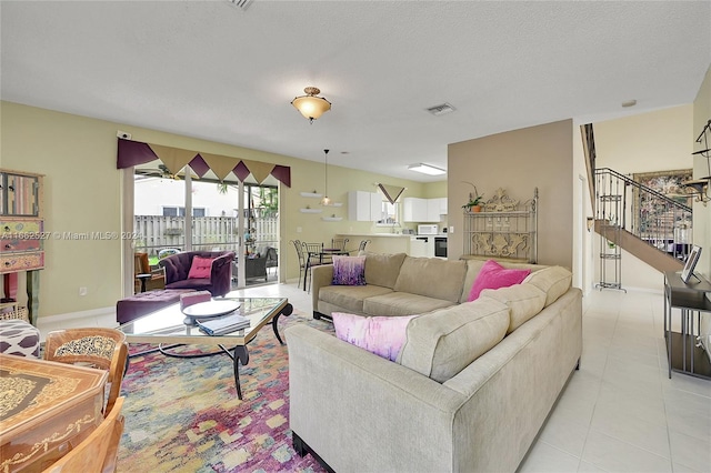 living room featuring a textured ceiling and light tile patterned floors