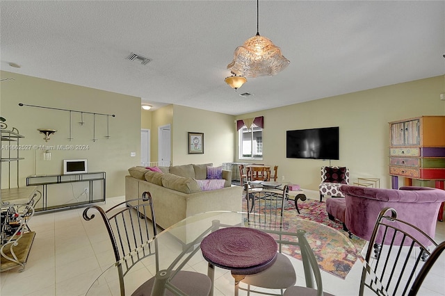 tiled dining space with a textured ceiling