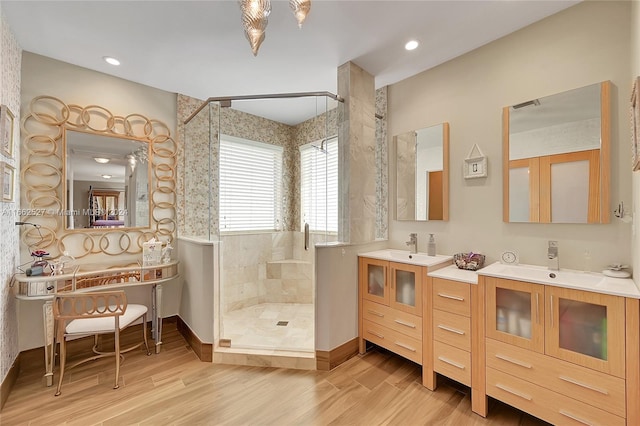 bathroom featuring wood-type flooring, vanity, and tiled shower