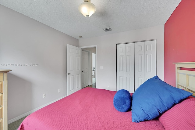 bedroom featuring a textured ceiling, carpet floors, and a closet