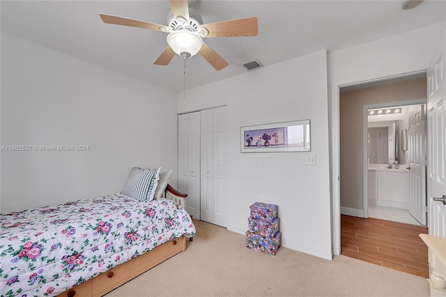 carpeted bedroom featuring a textured ceiling, ceiling fan, and a closet