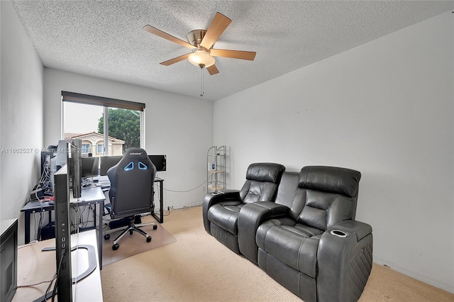 carpeted home office with ceiling fan and a textured ceiling