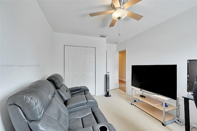 living room featuring a textured ceiling, ceiling fan, and carpet floors