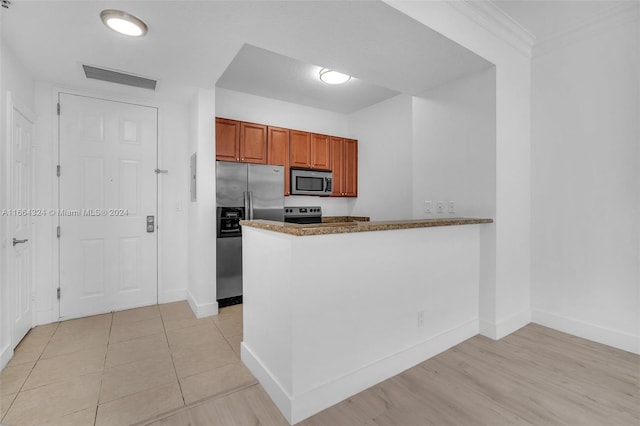 empty room with ornamental molding and light hardwood / wood-style floors