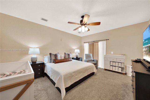 bedroom with multiple windows, ceiling fan, and light carpet